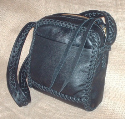 This Black messenger purse is about 8" wide by 8.5" high by 3". It has two full width pockets - one on the outside front and another on the inside back. It has no side pockets. Besides all the seams be braided together, it's 1-1/2" wide strap has braiding down the center length of it. 